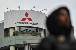 A pedestrian walks past a branch office of Japanese automaker Mitsubishi Motors along a street in Tokyo on February 3, 2025. Mitsubishi Motors were expected to announce their third quarter earnings on February 3. (Photo by Richard A. Brooks / AFP) (Photo by RICHARD A. BROOKS/AFP via Getty Images)