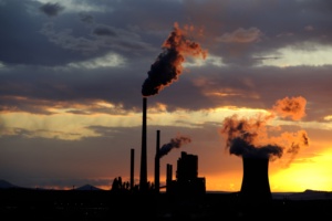 Coal power station with smoking chimneys in sunset with cloudy sky, industrial landscape