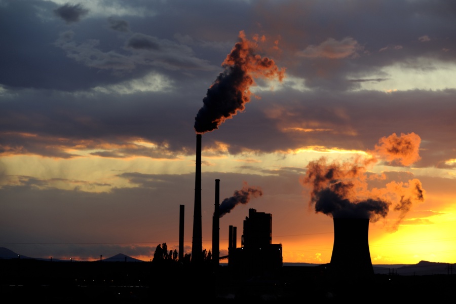 Coal power station with smoking chimneys in sunset with cloudy sky, industrial landscape