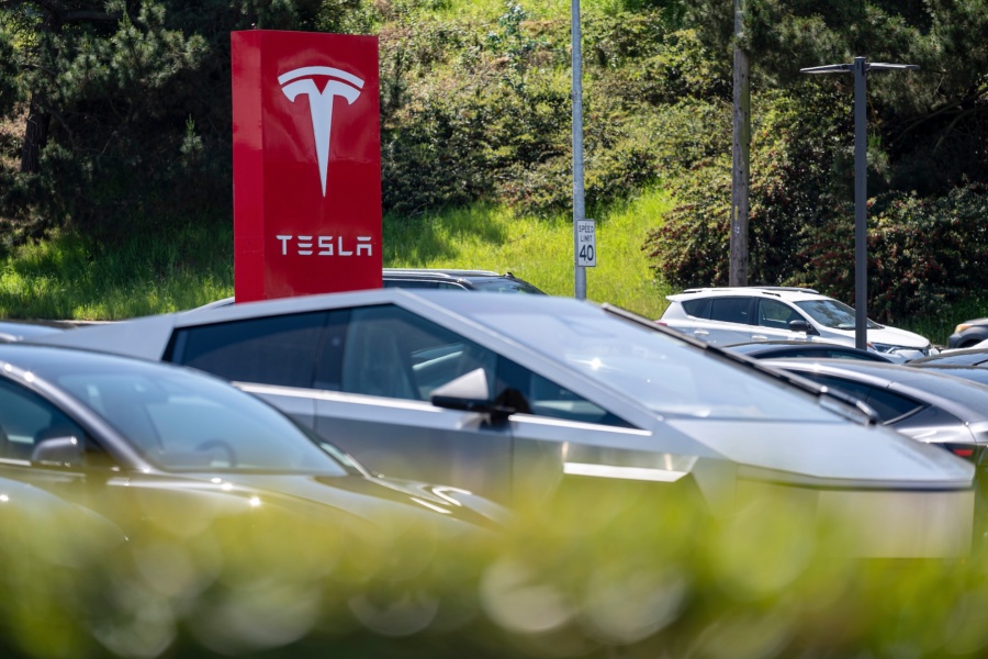 Signage at a Tesla store in Colma, California, US, on Monday, April 21, 2025. Tesla Inc. shares fell on renewed questions over Elon Musk's role with the federal government and uncertainty over the company's plans to introduce a lower-cost electric vehicle. Photographer: David Paul Morris/Bloomberg