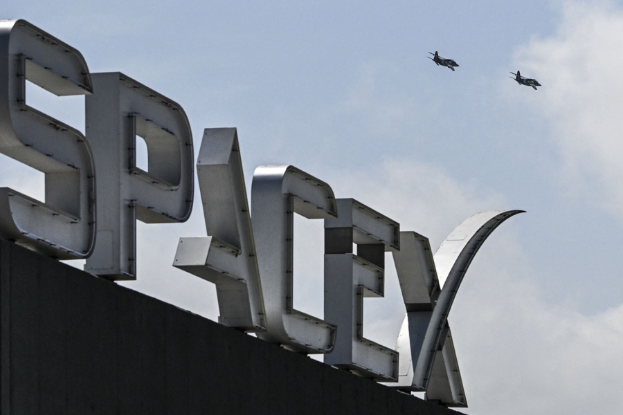 US billionaire businessman and pilot Jared Isaacman flies in formation aboard a fighter jet over the SpaceX sign, close to the Starship spacecraft, before his third test flight from Starbase in Boca Chica, Texas, on March 13, 2024. Elon Musk's SpaceX announced it was eyeing March 14 as the earliest date for the next test launch of its giant Starship rocket, with which it hopes to one day colonize Mars. Two previous attempts have ended in spectacular explosions, though the company has adopted a rapid trial-and-error approach in order to accelerate development. (Photo by CHANDAN KHANNA/AFP via Getty Images)